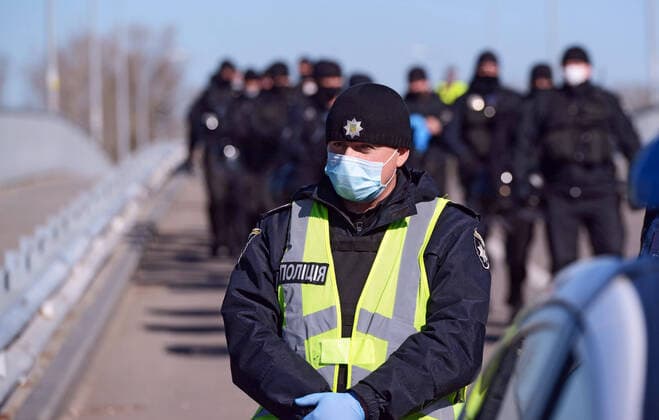 KYIV, UKRAINE - APRIL 06, 2020 - Officer of the National Police blocks the Venetian walking bridge that leads to the outdoor sports ground, Kyiv, capital of Ukraine. Police block entrance to Hydropark sports ground in capital  Copyright: xYevhenxKotenkox