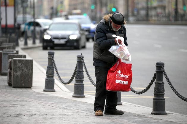 ST PETERSBURG, RUSSIA - APRIL 6, 2020: A homeless man checks a bag of food and essential supplies left by volunteers of the Nochlezhka charity as part of the initiative held in St Petersburg and Moscow to support homeless people during the COVID-19 pandemic. Under the initiative, such bags are handed out to homeless people or left for them in public places. Peter Kovalev TASS  TS0D48FC