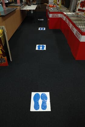 (200406) -- CANBERRA, April 6, 2020 -- Photo taken on April 6, 2020 shows signs on the ground reminding people of social distancing at a store in Canberra, Australia. (Photo by Xinhua) AUSTRALIA-CANBERRA-COVID-19-SOCIAL DISTANCING SIGNS (CN) ChuxChen 