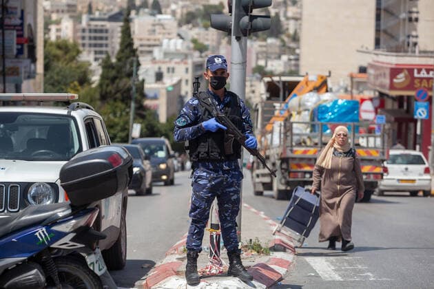 (200406) -- BETHLEHEM, April 6, 2020 (Xinhua) -- A Palestinian police officer stands guard at a street during a campaign to seize drivers who violate the emergency law in the West Bank city of Bethlehem, April 6, 2020. Palestine declared on Monday the full lockdown of four villages in the West Bank, as the COVID-19 cases in Palestine has climbed to 252. (Photo by Luay Sababa Xinhua) MIDEAST-BETHLEHEM-COVID-19 