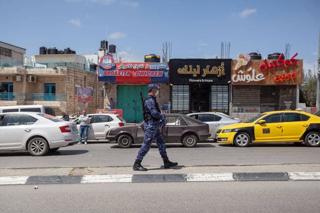 (200406) -- BETHLEHEM, April 6, 2020 (Xinhua) -- A Palestinian police officer guards the seized cars during a campaign to seize drivers who violate the emergency law in the West Bank city of Bethlehem, April 6, 2020. Palestine declared on Monday the full lockdown of four villages in the West Bank, as the COVID-19 cases in Palestine has climbed to 252. (Photo by Luay Sababa Xinhua) MIDEAST-BETHLEHEM-COVID-19 