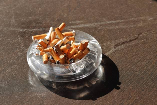 Aschenbecher mit Zigarettenstummeln *** Ashtray with cigarette butts 1098600377