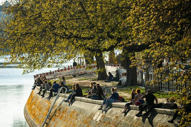 Menschen geniessen die Sonne am Landwehrkanal in Berlin am 6. April 2020. Um die Verbreitung des Coronavirus (SARS-CoV-2) zu verlangsamen beschlossen Bund und Laender weitere Restriktionen. Nachdem Museen, Theatern, Sportveranstaltungen usw verboten wurden sind seit einigen Tagen weitere verschaerfte Massnahmen in Kraft getreten wie z.B. Verbot von Versammlungen in der Oeffentlichkeit mit mehr als zwei Personen, Einhaltung von Mindestabstand zwischen Personen und Schliessung von Gastronomiebetrieben mit Ausnahme von Abholung und Lieferung. Coronavirus in Berlin