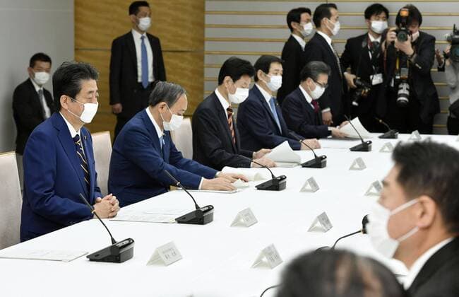 New coronavirus Japanese Prime Minister Shinzo Abe (L) attends an informal policy meeting at his office in Tokyo on April 7, 2020. The meeting led by the government and the ruling coalition was held ahead of the scheduled declaration later in the day by Abe of a state of emergency in Tokyo and other big cities in view of a recent surge in coronavirus infections. 