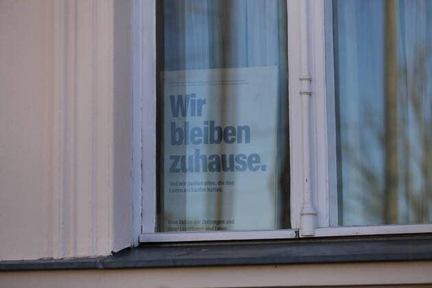 Ein Schild mit der Aufschrift Wir bleiben zuhause steht in einem Fenster, Potsdam, 6. April 2020. Um die Ausbreitung des Coronavirus Sars-CoV-2 zu verlangsamen gelten zur Zeit Ausgangs- und Kontaktbeschränkungen. Coronavirus Potsdam