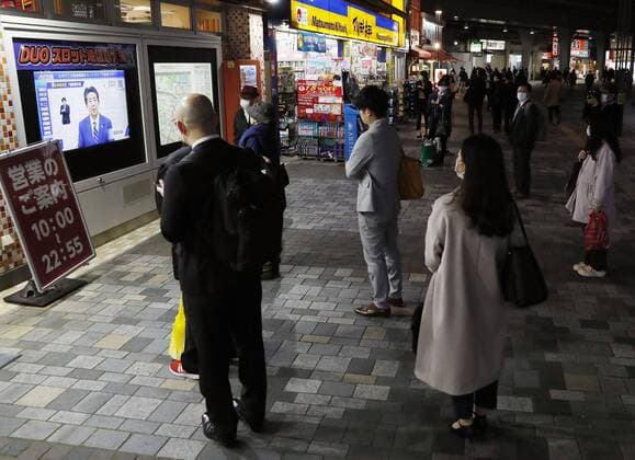 New coronavirus People watch TV screens in Tokyo s Yurakucho area on April 7, 2020, displaying news that Japanese Prime Minister Shinzo Abe spoke at a press conference after declaring a state of emergency in the capital and other big cities in response to a recent surge in coronavirus infections. 