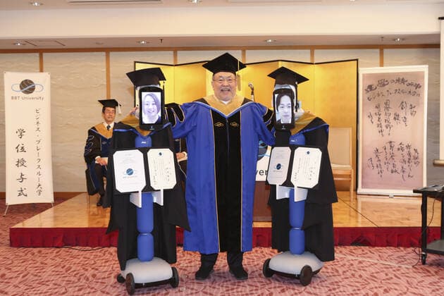 A Japanese University has held the world s first online graduation ceremony using robots due to the coronavirus pandemic. Students at Business Breakthrough University in Tokyo didn t get a traditional ceremony, but had the next best thing using newme telepresensence robots and a tablet hosting a Zoom call. Graduates had the experience of walking across the stage and accepting their diplomas at the Hotel Grand Palace in Tokyo, virtually on March 28, all while self-isolating at home. The robots were dressed in a cap and gown and fitted with tablets on their heads, allowing students to show their face using Zoom. When the moderator called the name, a newme wearing a graduation gown and hat from BBT University appeared on the tablet with the face of the graduate who operated it, and the diploma was handed over by President Omae Kenich Copyright: xx 40432769 EDITORIAL USE ONLY. NOT FOR USE BY NEWSPAPERS BASED IN THE UK.