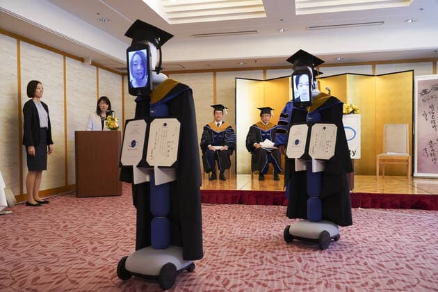 A Japanese University has held the world s first online graduation ceremony using robots due to the coronavirus pandemic. Students at Business Breakthrough University in Tokyo didn t get a traditional ceremony, but had the next best thing using newme telepresensence robots and a tablet hosting a Zoom call. Graduates had the experience of walking across the stage and accepting their diplomas at the Hotel Grand Palace in Tokyo, virtually on March 28, all while self-isolating at home. The robots were dressed in a cap and gown and fitted with tablets on their heads, allowing students to show their face using Zoom. When the moderator called the name, a newme wearing a graduation gown and hat from BBT University appeared on the tablet with the face of the graduate who operated it, and the diploma was handed over by President Omae Kenich Copyright: xx 40432772 EDITORIAL USE ONLY. NOT FOR USE BY NEWSPAPERS BASED IN THE UK.