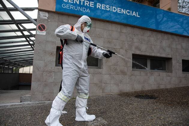 April 7, 2020, Girona, Spain: A civil protection agent dressed in a protective suit sprays disinfectants at the Centre Residencial Gerunda..During the Covid-19 crisis, the civil protection agents of Gerona carry out disinfection tasks in residential areas. Girona Spain - ZUMAs197 20200407_zaa_s197_026 Copyright: xDavidxApariciox
