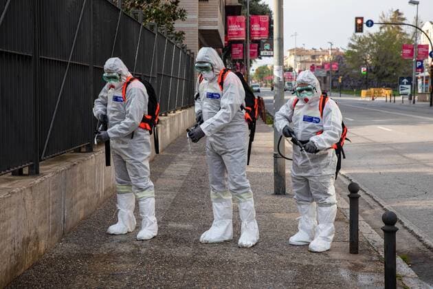 April 7, 2020, Girona, Spain: Civil protection agents dressed in protective suits spray disinfectants on the streets..During the Covid-19 crisis, the civil protection agents of Gerona carry out disinfection tasks in residential areas. Girona Spain - ZUMAs197 20200407_zaa_s197_028 Copyright: xDavidxApariciox