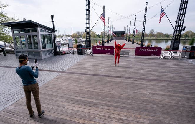 A YouTube performer known as Elmo at the Wharf dances on the Wharf in Washington, D.C. during the Coronavirus pandemic and stay at home order, on Tuesday, April 7, 2020. The performer said she was attempting to bring smiles and joy to the people in the apartment buildings that overlook the area.  WAP20200407316 KEVINxDIETSCH