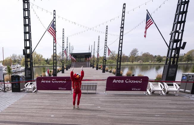 A YouTube performer known as Elmo at the Wharf dances on the Wharf in Washington, D.C. during the Coronavirus pandemic and stay at home order, on Tuesday, April 7, 2020. The performer said she was attempting to bring smiles and joy to the people in the apartment buildings that overlook the area.  WAP20200407326 KEVINxDIETSCH