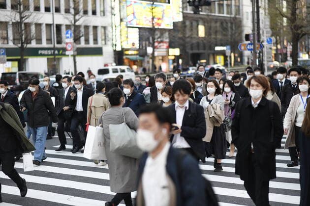 TOKYO, JAPAN - APRIL 7: Commuters wearing masks walk across the road in Shinjuku business district, Tuesday, April 7, 2020, in Tokyo. Japanese Prime Minister Shinzo Abe declared a state of emergency on Tuesday for Tokyo and six other prefectures to ramp up defenses against the spread of the coronavirus. (Photo: Richard Atrero de Guzman AFLO)  (125133450)