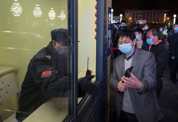 (200408) -- WUHAN, April 8, 2020 -- A passenger shows the health code to a train staff member at Wuchang Railway Station in Wuhan, central China s Hubei Province, late April 7, 2020. Wuhan, the megacity in central China, started lifting outbound travel restrictions from Wednesday after almost 11 weeks of lockdown to stem the spread of COVID-19. ) CHINA-HUBEI-WUHAN-OUTBOUND TRAVEL RESTRICTIONS-LIFT (CN) FeixMaohua 