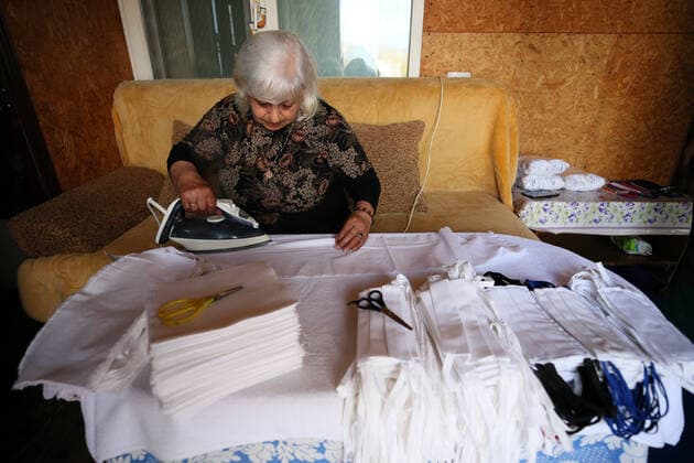 SOCHI, RUSSIA - APRIL 8, 2020: Asmik Barsegyan ironing fabric for face masks. The Barsegyans receive materials from the Sochi city hall, sew face masks and give them to volunteers and healthcare workers attending patients under quarantine. Dmitry Feoktistov TASS  TS0D4DA0