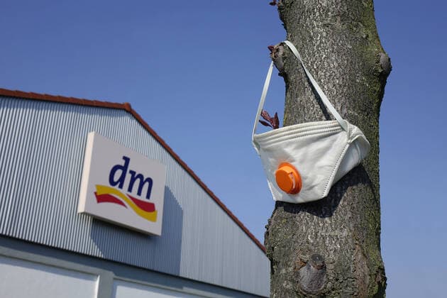 dm und Mundschutz dm und Mundschutz, 08.04.2020, Werder, Brandenburg, Vor einem dm-Geschäft hängt ein Mundschutz an einem Baumstamm.