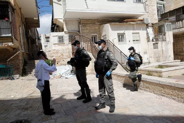 (200408) -- JERUSALEM, April 8, 2020 (Xinhua) -- Israeli police officers wearing face masks checks a pedestrian in Mea Shearim neighborhood in Jerusalem, on April 8, 2020. Israel reported six new death cases from the novel coronavirus, bringing the death toll to 71, the state s Ministry of Health said Wednesday. The ministry added that a total of 9,404 people in Israel were tested positive for COVID-19 so far. (Photo by Gil Cohen Magen Xinhua) MIDEAST-JERUSALEM-COVID-19-CURFEW 