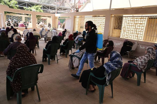 (200408) -- CAIRO, April 8, 2020 (Xinhua) -- A worker sprays disinfectants as senior citizens wait to receive their pension at a youth center on the outskirts of northern Cairo, Egypt, on April 8, 2020. The Egyptian Health Ministry reported on Wednesday 110 new cases and nine deaths of COVID-19, raising the total number of cases in the country to 1,560, including 103 deaths. (Xinhua Ahmed Gomaa) EGYPT-CAIRO-COVID-19 