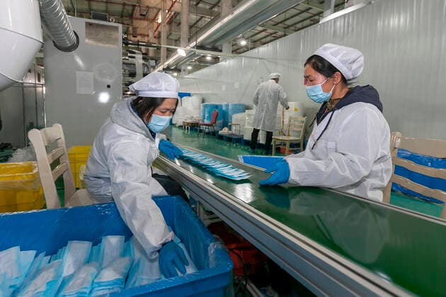 (200409) -- SHANGHAI, April 9, 2020 -- Workers pack protective masks at a mask plant of Chinese underwear brand Threegun Group in Shanghai, east China, April 8, 2020. The mask production of the company has kicked into high gear recently with the daily output reaching one million pieces. (Photo by Xinhua) CHINA-SHANGHAI-MASKS PRODUCTION (CN) WangxXiang 