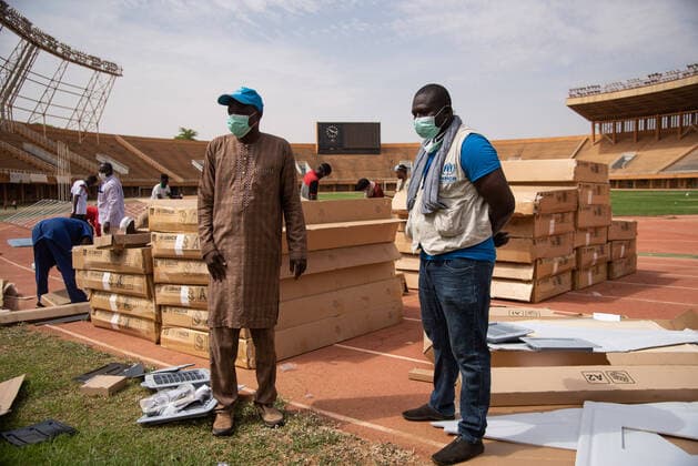 Two staff member is watching the setting up of the Refugee Housing Units (RHU) at the General Seyni Kountche Stadium which has been requisitioned by the Government of Niger to set up an isolation site in Niamey as part of the Covid-19 preparedness and response plan. The Office of the United Nations High Commissioner for Refugees (UNHCR) is supporting the establishment of isolation sites in Niamey and the region through the installation of Refugee Housing Units (RHUs) equipped with beds and air conditioning. UNHCR will provide a total of 350 equipped RHUs throughout the country for a total of 700 places, including 100 places for the Nigerian capital.  NicolasxRemenex xLexPictorium LePictorium_0227381