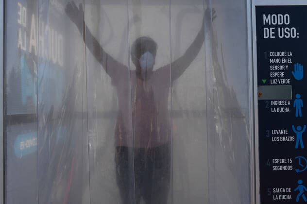 (200409) -- SANTIAGO, April 9, 2020 (Xinhua) -- Consumers pass through a disinfection tunnel before entering a market in Santiago, Chile, April 8, 2020. (Photo by Jorge Villegas Xinhua) CHILE-SANTIAGO-DISINFECTION CHANNEL-COVID-19 