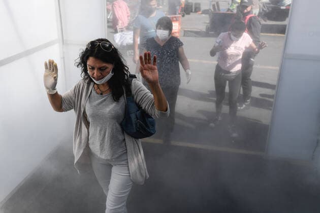 (200409) -- SANTIAGO, April 9, 2020 (Xinhua) -- Consumers pass through a disinfection tunnel before entering a market in Santiago, Chile, April 8, 2020. (Photo by Jorge Villegas Xinhua) CHILE-SANTIAGO-DISINFECTION CHANNEL-COVID-19 