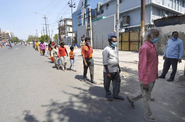 NOIDA, INDIA - APRIL 7: People queue while keeping distance at a food distribution by Noida Authority, on day fifteen of the 21 day nationwide lockdown to curb the spread of coronavirus, at Sector 16, on April 7, 2020 in Noida, India. (Photo by Sunil Ghosh Hindustan Times ) Government And NGOs Provide Food To Homeless And Poor Amid Lockdown To Prevent Covid-19