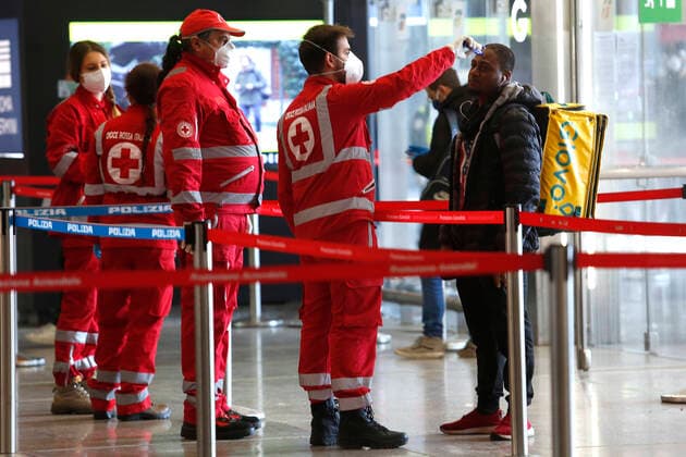 A volounteer of the Red Cross takes the temperature on a guy working for Glovo delivery Rome April 9th 2020. Termini train station. Due to the coronavirus emergency, bodyscanner were introduced at the mayor train stations. Since this morning, the Red Cross together with the volunteers of the Order of Doctors, will take the temperature with a body scanner on passenger arriving at the train stations. Photo Samantha Zucchi Insidefoto SamanthaxZucchi