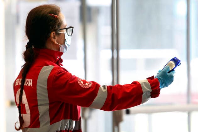 A volunteer of the Red Cross shows a body scanner Rome April 9th 2020. Termini train station. Due to the coronavirus emergency, bodyscanner were introduced at the mayor train stations. Since this morning, the Red Cross together with the volunteers of the Order of Doctors, will take the temperature with a body scanner on passenger arriving at the train stations. Photo Samantha Zucchi Insidefoto SamanthaxZucchi