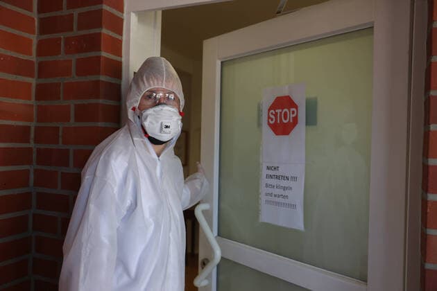 Coronavirus, Maskenmangel in deutschen Arztpraxen, Arzt, Arztpraxis, Hausarzt, Arzt mit Mundschutz, FFP2-Maske , Atemschutzmaske mit Filter, und Einmalschutzkittel, Schutzbrille,