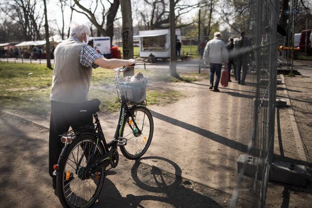 Besucher mit Mundschutz zeichnen sich hinter einem Zaun ab auf dem Wochenmarkt an der Lingnerallee in Dresden, 09.04.2020. Aufgrund der Verbreitung des Coronaviruses gibt es erstmals eine Maskenpflicht auf einem Wochenmarkt in Dresden. Dresden Deutschland