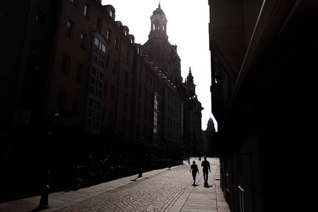 Zwei Personen zeichnen sich vor der Frauenkirche ab in Dresden, 09.04.2020. Aufgrund der Verbreitung des Coronaviruses gibt es deutschlandweit Ausgangsbeschraenkungen. Dresden Deutschland