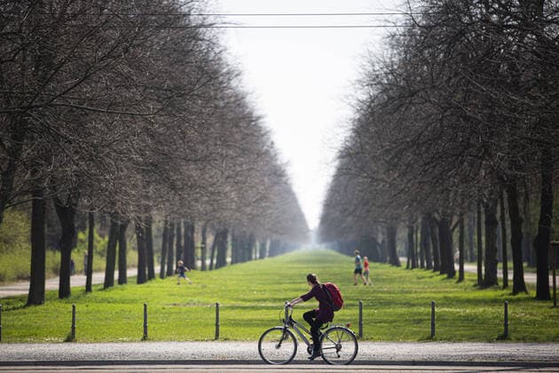 Eine Frau faehrt Fahrrad entlang des Grossen Gartens in Dresden, 09.04.2020. Aufgrund der Verbreitung des Coronaviruses gibt es deutschlandweit Ausgangsbeschraenkungen. Dresden Deutschland