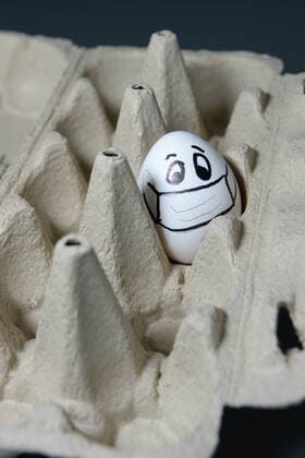 Ostern während Corona ist geprägt von Abstandsregeln und Isolation - ein Hühnerei allein in einer Packung