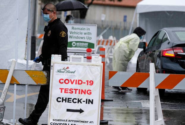 April 9, 2020, Los Angeles, California, U.S: A police officer wearing a mask directs motorists during a drive-through COVID-19 testing in a parking lot of the Rose Bowl in Pasadena, California on Thursday, April 9, 2020. Los Angeles U.S. - ZUMAc68_ 20200409_zaf_c68_005 Copyright: xRingoxChiux