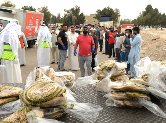 (200409) -- FARWANIYA GOVERNORATE (KUWAIT), April 9, 2020 (Xinhua) -- Residents in the area of Jleeb Al-Shuyoukh queue up to receive food in Farwaniya Governorate, Kuwait, on April 9, 2020. Kuwaiti government distributed on Thursday food baskets to residents of areas of Mahboula and Jleeb Al-Shuyoukh which are under lockdown to curb the spread of COVID-19. Kuwait reported on Thursday 55 new COVID-19 cases, bringing the total number in the country to 910, the health ministry said in a statement. (Photo by Asad Xinhua) KUWAIT-FARWANIYA GOVERNORATE-COVID-19-FOOD DISTRIBUTION 