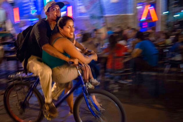 April 13, 2014, Nicaragua: Local couple riding a bicycle in La Calzada a gastronomic street in Granada Nicaragua with lots of tourists and locals enjoying fine food outdoors. Granada - Nicaragua Nicaragua - ZUMAr133 20140413_zap_r133_012 Copyright: xSergixReboredox