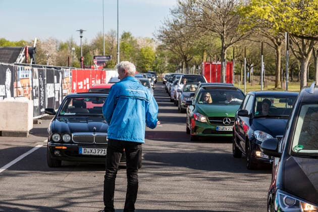 Ökumenischer Gottesdienst an Karfreitag im Autokino auf dem Messeparkplatz in Düsseldorf, eine Antwort auf die ungewohnten Umstände aufgrund der Coronavirus Pandemie ÐÊdie Autoschlange am Eingang