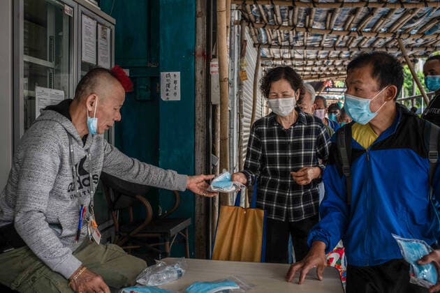 April 10, 2020, Hong Kong, China: A homeless woman receives a surgical mask from a volunteer as a preventive measure against the spread of Coronavirus..As the coronavirus pandemic worsens, thousands of Hong Kong residents who live in cramped coffin homes or homeless situation are struggling to adjust to their new reality. Coronavirus cases in Hong Kong are close to the 1,000 mark. Hong Kong China - ZUMAs197 20200410_zaa_s197_025 Copyright: xSOPAxImagesx