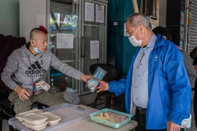 April 10, 2020, Hong Kong, China: A homeless man receives a surgical mask and a sanitizing products kit from a volunteer worker as a preventive measure against the spread of Coronavirus..As the coronavirus pandemic worsens, thousands of Hong Kong residents who live in cramped coffin homes or homeless situation are struggling to adjust to their new reality. Coronavirus cases in Hong Kong are close to the 1,000 mark. Hong Kong China - ZUMAs197 20200410_zaa_s197_027 Copyright: xSOPAxImagesx