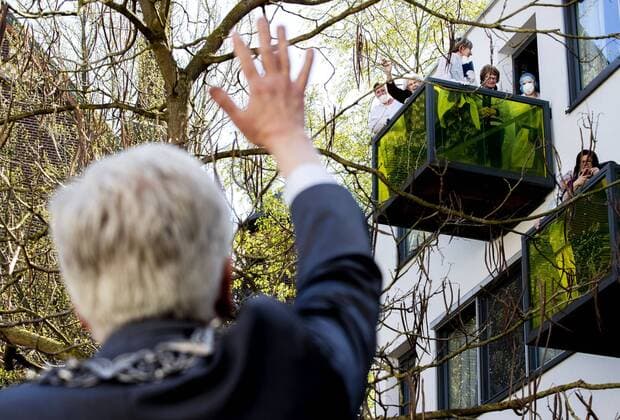 2020-04-10 14:07:11 TILBURG - Theo Weterings, burgemeester van Tilburg, deelt via een ladder bloemen uit aan ouderen in een verzorgingshuis. Op Goede Vrijdag deelt de sierteeltsector op 2200 locaties bloemen uit aan ouderen die vanwege de coronacrisis geen bezoek mogen ontvangen. ANP REMKO DE WAAL  Copyright: xANPx xREMKOxDExWAALx x409445001x
