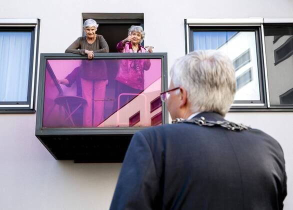 2020-04-10 14:08:21 Theo Weterings, mayor of Tilburg, handout flowers via a ladder to the elderly in a care home in Tilburg, The Netherlands, 10 April 2020. On Good Friday, the floricultural sector distributes flowers to elderly people at 2,200 locations who are not allowed to receive visitors due to the corona crisis. ANP REMKO DE WAAL  Copyright: xANPx xREMKOxDExWAALx x409445031x