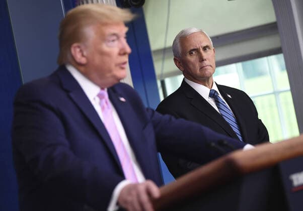 President Donald Trump speaks as Vice President Mike Pence listens at a Coronavirus briefing at the White House on Friday, April 10, 2020, in Washington, DC. With the U.S. death toll from the coronavirus pandemic expected to peak over the weekend, most of the country will be firmly under stay-at-home orders on Easter Sunday.  WAS2020410521 KEVINxDIETSCH