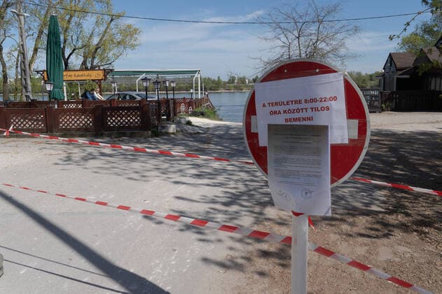 (200411) -- BUDAPEST, April 11, 2020 -- A notice at an entrance to a public park informs people of the closure time on the Easter weekend due to the COVID-19 pandemic in Budapest, Hungary, on April 10, 2020. (Photo by Xinhua) HUNGARY-BUDAPEST-COVID-19-PARK CLOSURE AttilaxVolgyi 