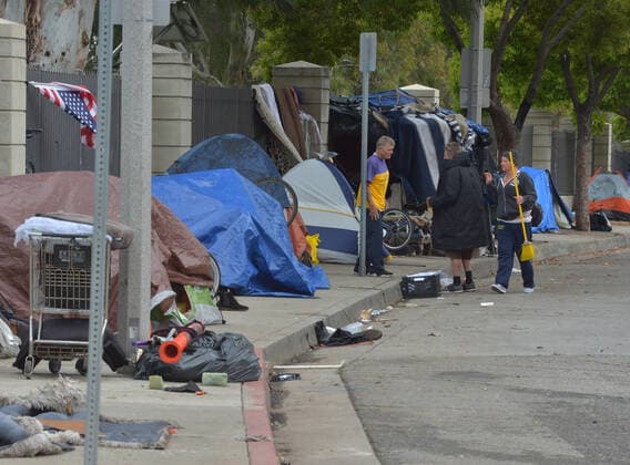 Homeless denizens socialize at an encampment, adjacent to the West Los Angeles VA Medical Center during the coronavirus pandemic in Los Angeles on Friday, April 10, 2020.  LAP2020041012 JIMxRUYMEN