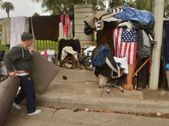 Homeless veterans socialize at an encampment, adjacent to the West Los Angeles VA Medical Center during the coronavirus pandemic in Los Angeles on Friday, April 10, 2020.  LAP2020041022 JIMxRUYMEN