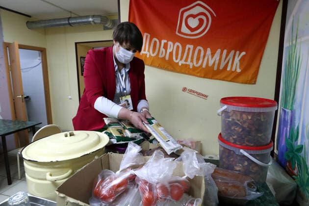 ST PETERSBURG, RUSSIA - APRIL 11, 2020: A volunteer of the DobroDomik Charity Fund packing free groceries for solitary elderly people. Alexander Demianchuk TASS  TS0D54CB