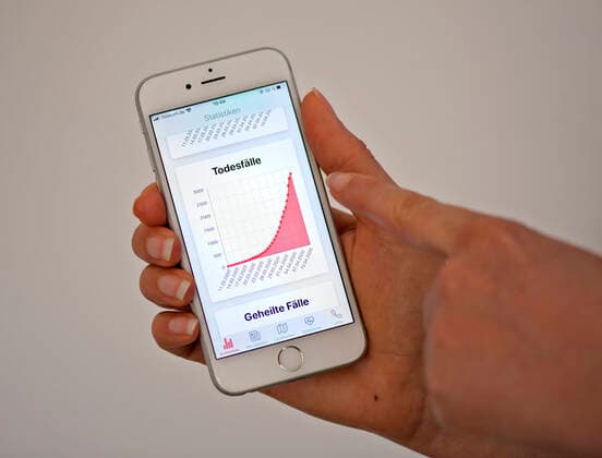 11.04.2020, Coronavirus-App auf einem Smartphone. Rote Kurve die Zahl der in Deutschland Todesfälle mit Corona-Virus (Stand 11.04.2020). 11.04.2020, Coronavirus-App auf dem Smartphone 11.04.2020, Coronavirus-App auf dem Smartphone