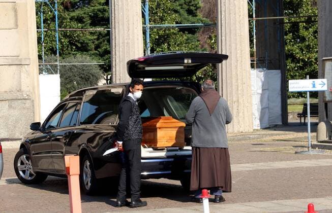 foto IPP clemente marmorino - Milano 11 04 2020 - emergenza coronavirus - cimitero maggiore- Nella foto un frate benedice una salma emergenza coronavirus - cimitero  0