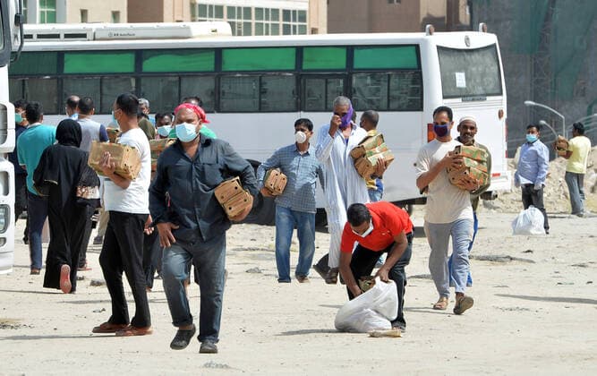 (200411) -- AHMADI GOVERNORATE, April 11, 2020 (Xinhua) -- Residents of area of Mahboula carry food distributed by the government after the area was locked down to curb the spread of novel coronavirus, in Ahmadi Governorate, Kuwait, April 11, 2020. The Kuwaiti government has decided to impose a complete lockdown on the areas of Mahboula and Jleeb Al-Shuyoukh for two weeks. Kuwait reported on Saturday 161 new COVID-19 cases, bringing the total number of confirmed cases in the country to 1,154, the Health Ministry said in a statement. (Photo by Asad Xinhua) KUWAIT-AHMADI GOVERNORATE-FOOD DISTRIBUTION 